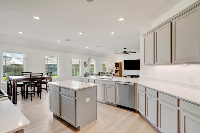 kitchen featuring dishwasher, sink, light hardwood / wood-style flooring, and gray cabinetry