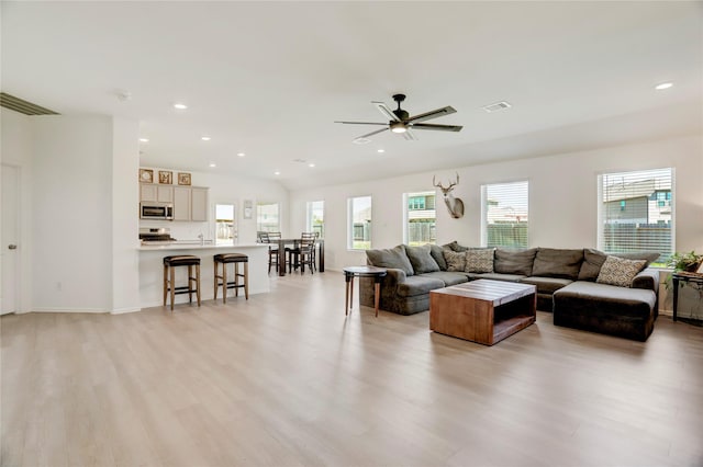 living room featuring light hardwood / wood-style floors and ceiling fan