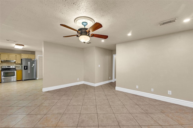 empty room with light tile patterned floors, a textured ceiling, and ceiling fan