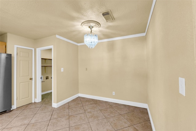 unfurnished dining area featuring ornamental molding, a chandelier, a textured ceiling, and light tile patterned floors