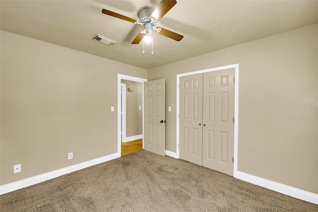 unfurnished bedroom featuring ceiling fan, carpet flooring, a closet, and a textured ceiling