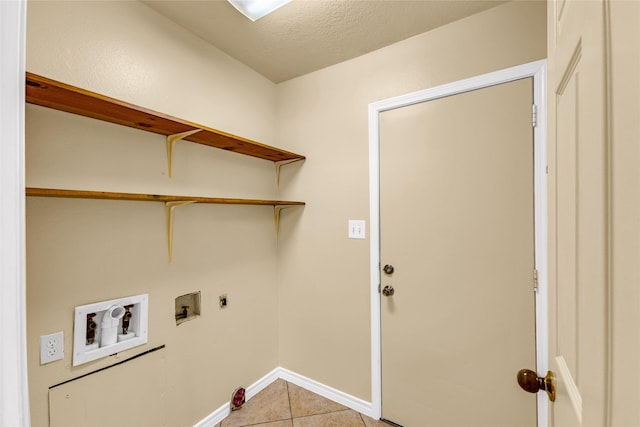 clothes washing area with washer hookup, hookup for an electric dryer, a textured ceiling, and light tile patterned flooring