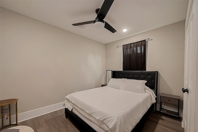 bedroom with dark hardwood / wood-style floors and ceiling fan