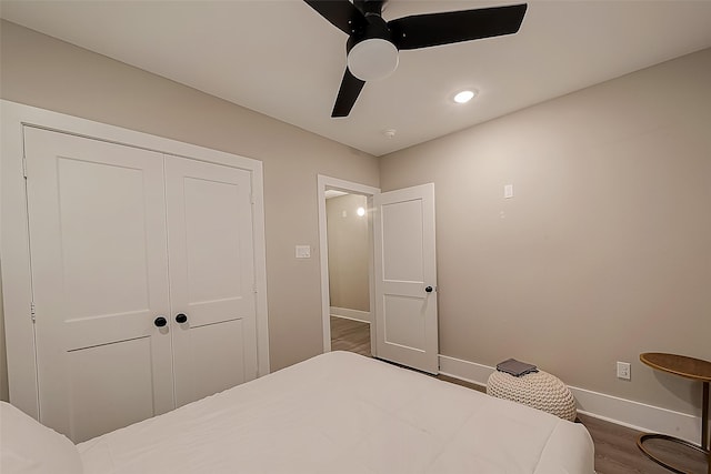 bedroom featuring dark wood-type flooring, ceiling fan, and a closet