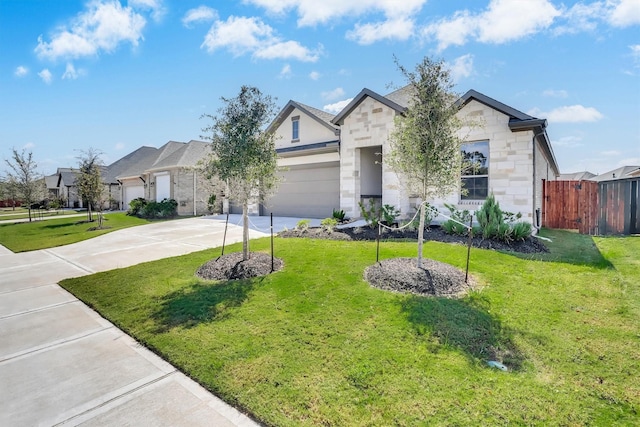 view of front of property featuring a front lawn, fence, concrete driveway, a garage, and stone siding