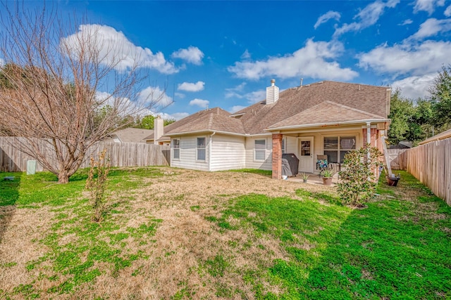 back of property featuring a yard and a patio area