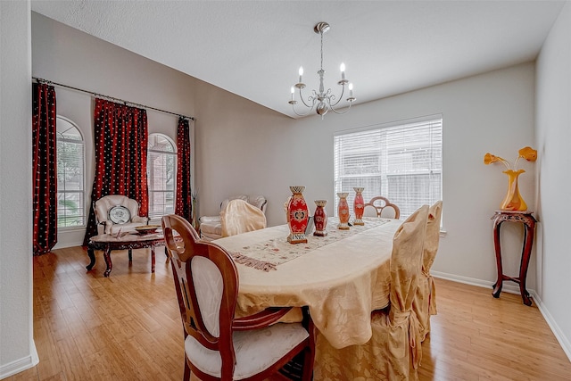 dining space featuring an inviting chandelier, a healthy amount of sunlight, and light hardwood / wood-style floors