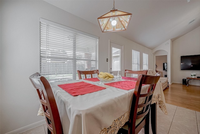 dining room with lofted ceiling and light tile patterned floors