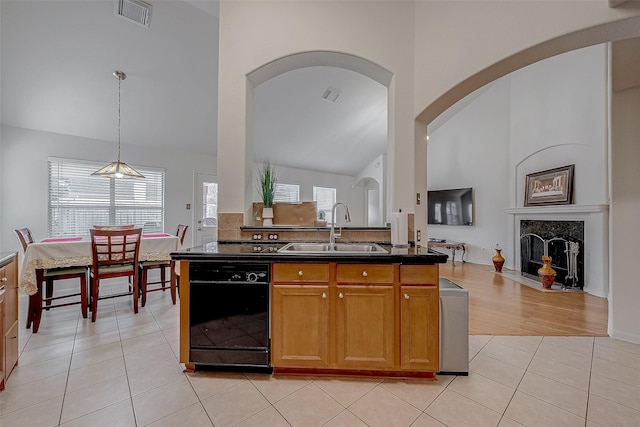 kitchen with pendant lighting, a fireplace, dishwasher, sink, and light tile patterned floors