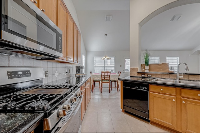 kitchen with light tile patterned flooring, sink, backsplash, hanging light fixtures, and stainless steel appliances