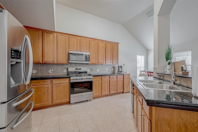 kitchen featuring sink, decorative backsplash, vaulted ceiling, and stainless steel appliances