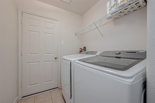 laundry area featuring washer and clothes dryer and light tile patterned floors