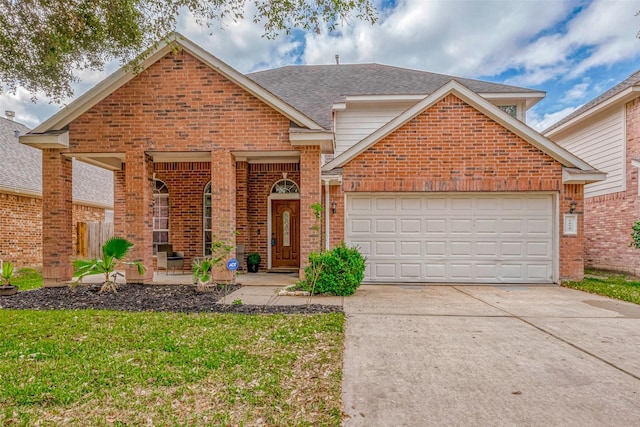 view of property featuring a garage and a front lawn