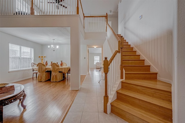 foyer featuring plenty of natural light, a towering ceiling, and light hardwood / wood-style flooring