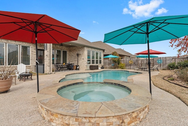 view of pool featuring a patio, a fire pit, a pool with connected hot tub, and fence