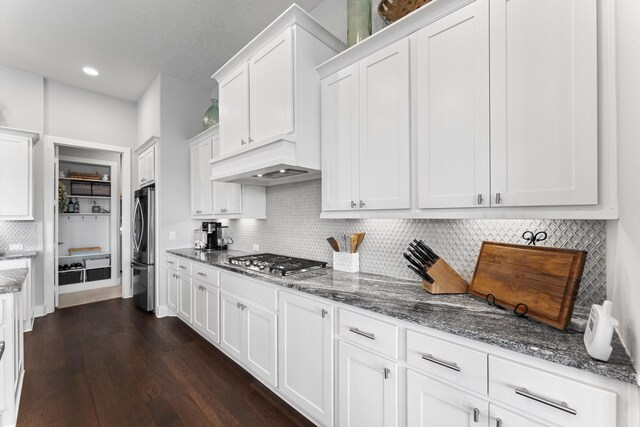 kitchen featuring stainless steel appliances, white cabinetry, and dark stone countertops