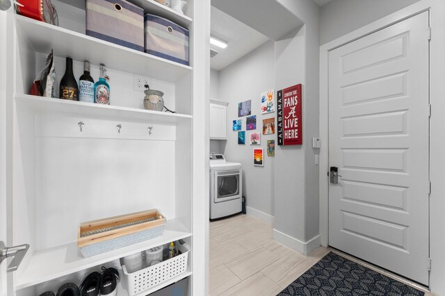 laundry room featuring cabinets, light hardwood / wood-style floors, and washing machine and dryer