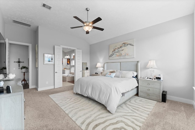 carpeted bedroom featuring lofted ceiling, connected bathroom, a textured ceiling, and ceiling fan