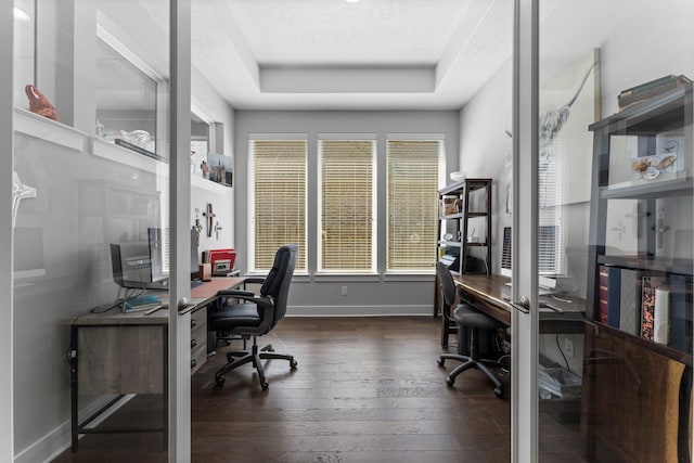 office with a tray ceiling and dark hardwood / wood-style flooring