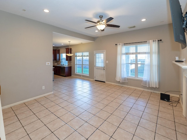 interior space featuring light tile patterned flooring, ceiling fan, a healthy amount of sunlight, and sink