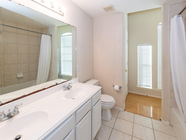 full bathroom featuring tile patterned flooring, vanity, toilet, and shower / bathtub combination with curtain