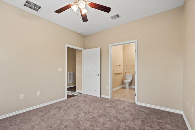 unfurnished bedroom with ceiling fan, ensuite bathroom, and light carpet