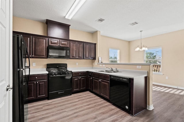 kitchen featuring sink, hanging light fixtures, black appliances, and kitchen peninsula