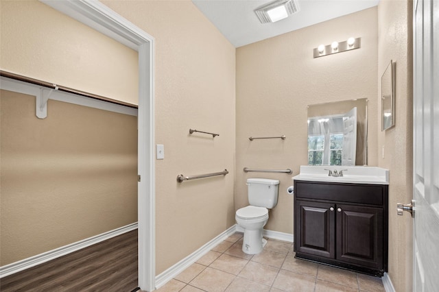 bathroom featuring vanity, tile patterned floors, and toilet