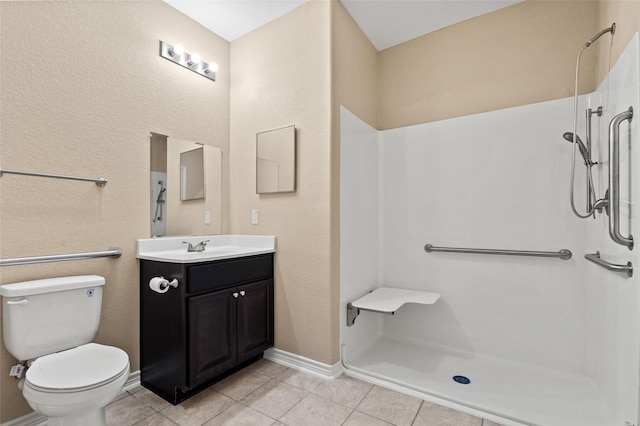 bathroom featuring tile patterned floors, toilet, vanity, and a shower