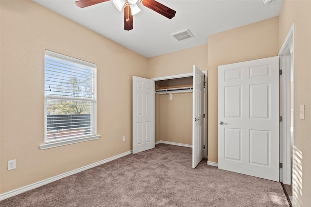 unfurnished bedroom featuring light carpet, a closet, and ceiling fan