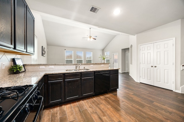 kitchen with vaulted ceiling, sink, dark hardwood / wood-style flooring, black appliances, and light stone countertops