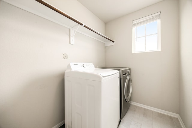 laundry area featuring separate washer and dryer and light hardwood / wood-style flooring