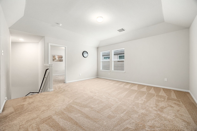 carpeted spare room featuring lofted ceiling