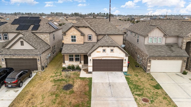 view of front of house with a garage, a front lawn, and solar panels