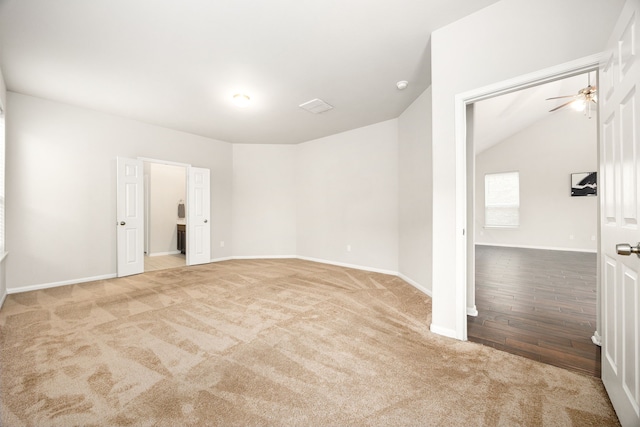 carpeted empty room featuring vaulted ceiling and ceiling fan