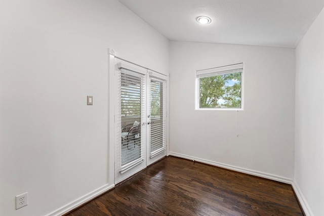 empty room with lofted ceiling and dark hardwood / wood-style floors