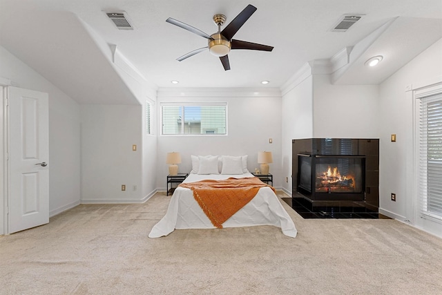 carpeted bedroom featuring ornamental molding, a tile fireplace, and ceiling fan