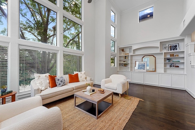 living room with ornamental molding, a towering ceiling, and dark hardwood / wood-style floors