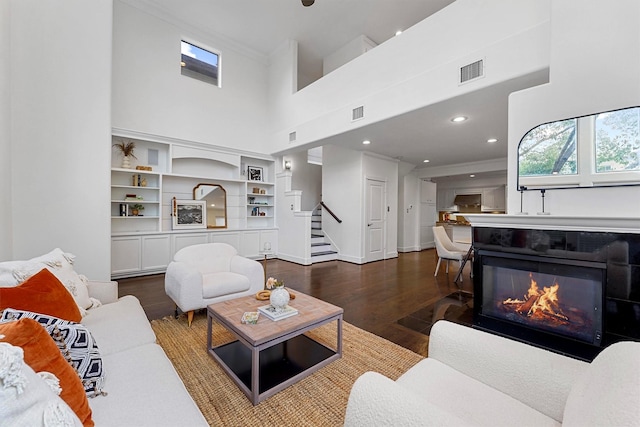 living room featuring a high ceiling and dark wood-type flooring