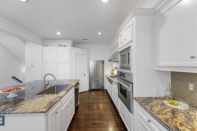 kitchen with stainless steel appliances, sink, white cabinets, and dark stone counters