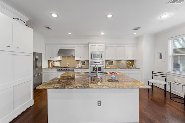 kitchen with stainless steel appliances, white cabinets, and dark stone counters