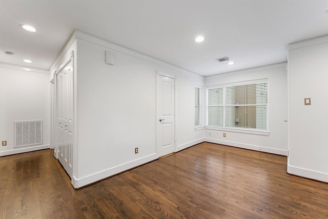 empty room with crown molding and dark hardwood / wood-style floors