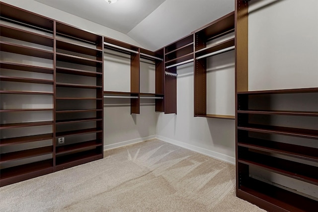 spacious closet featuring vaulted ceiling and carpet flooring