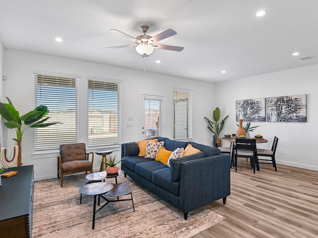 living room with light hardwood / wood-style floors and ceiling fan