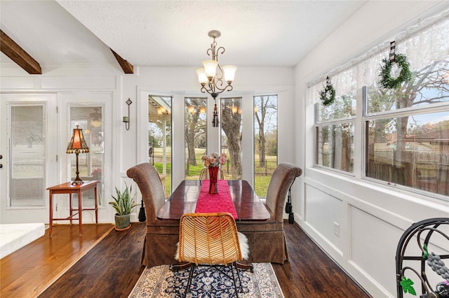 sunroom / solarium with beamed ceiling and an inviting chandelier