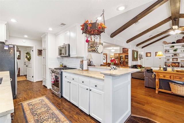 kitchen featuring vaulted ceiling with beams, white cabinets, light stone counters, stainless steel appliances, and dark wood-type flooring