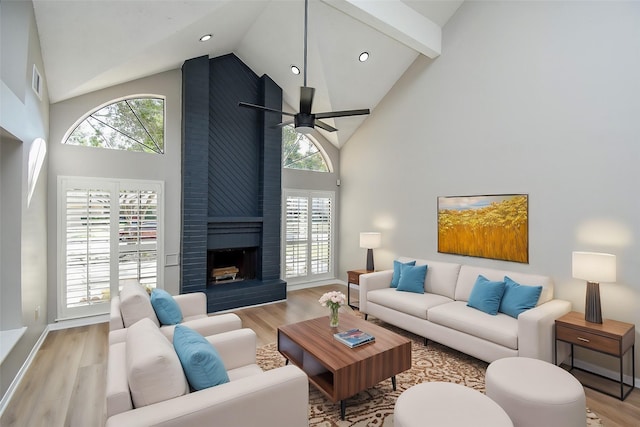 living room with ceiling fan, plenty of natural light, a fireplace, and light hardwood / wood-style floors