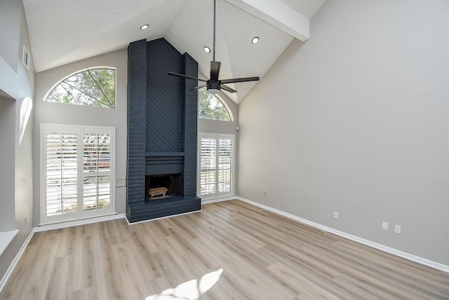 unfurnished living room featuring ceiling fan, light hardwood / wood-style flooring, a brick fireplace, and a wealth of natural light