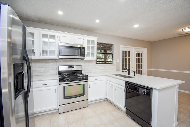 kitchen featuring french doors, sink, white cabinetry, appliances with stainless steel finishes, and kitchen peninsula