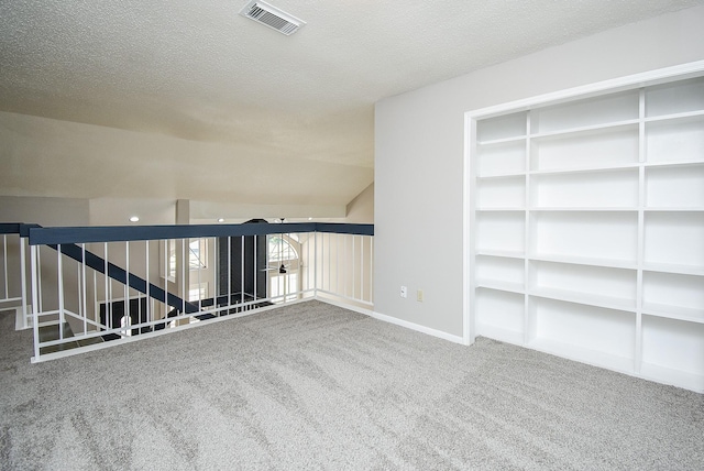 carpeted spare room featuring a textured ceiling